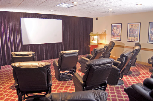 A cozy home theater setup featuring reclining chairs and a large screen for movie nights.