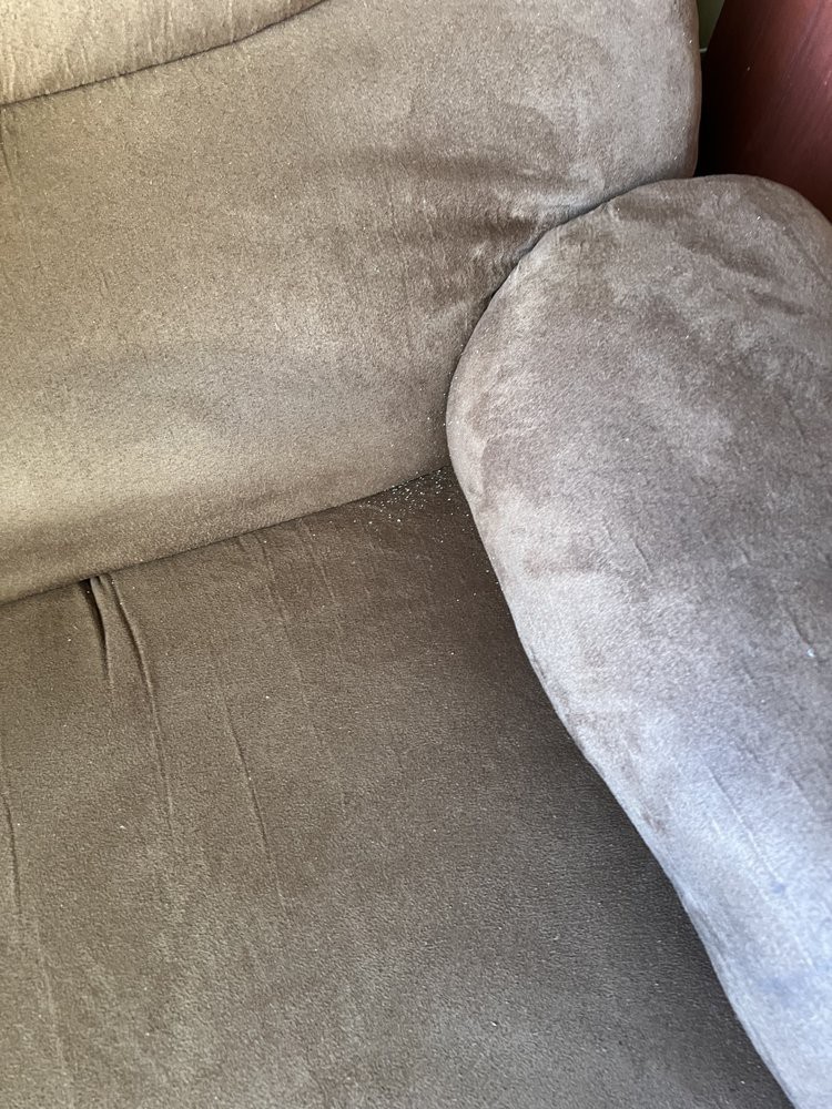 A close-up view of a fabric sofa with a cushion.