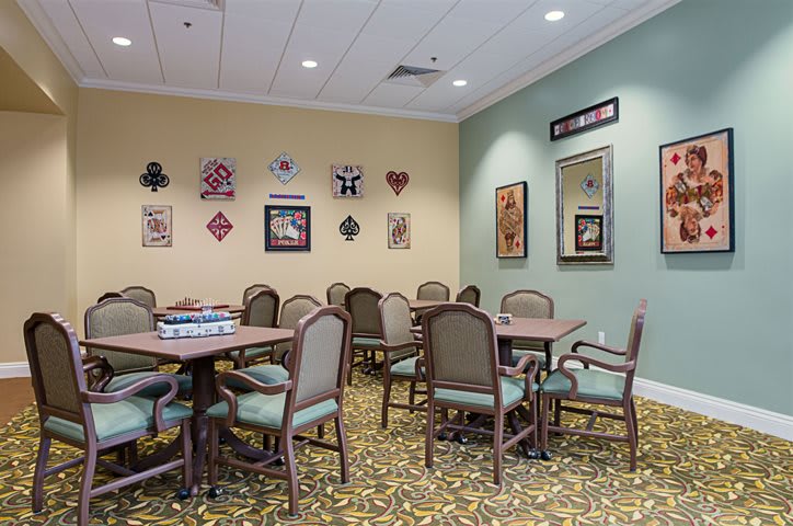 A furnished meeting room with tables and chairs, adorned with wall decorations and artwork.