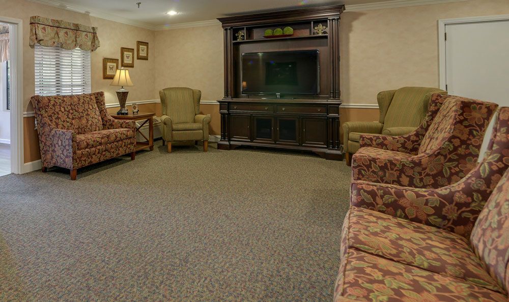 A cozy living room with comfortable seating and a television stand.
