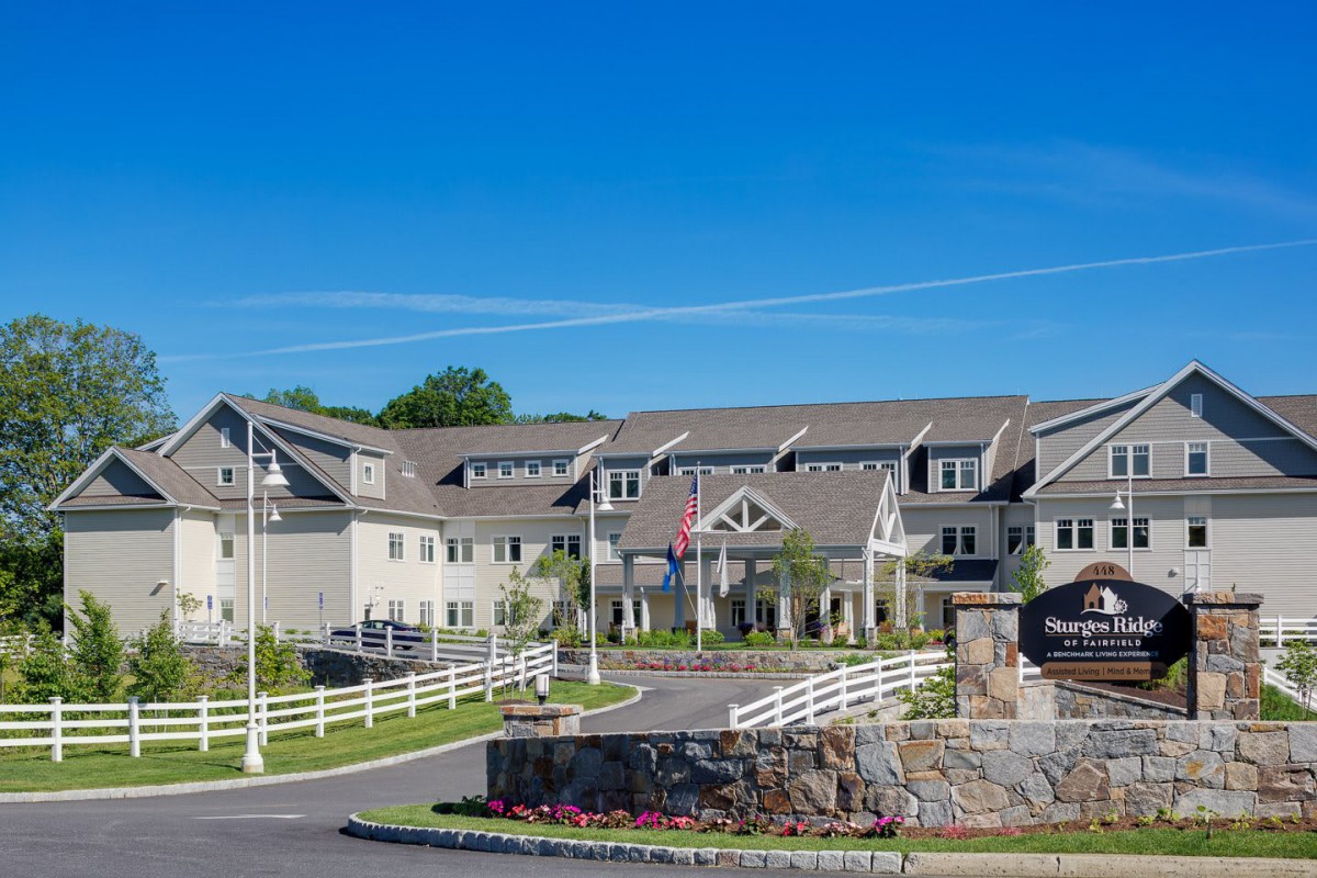 A large residential building with a neatly landscaped exterior and clear blue sky.