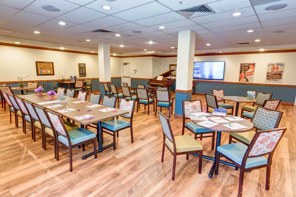 An empty restaurant dining area with neatly arranged tables and chairs on a wooden floor.