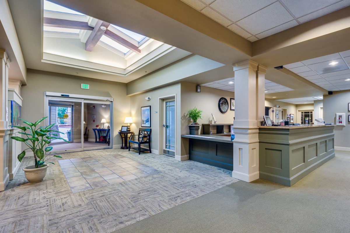A spacious lobby area with a reception desk and entrance doors.