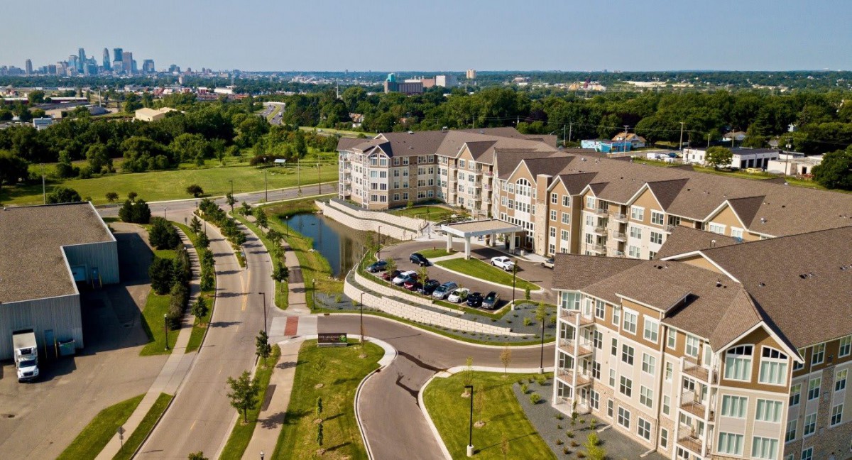 Aerial view of a modern apartment complex surrounded by landscaped roads and greenery.