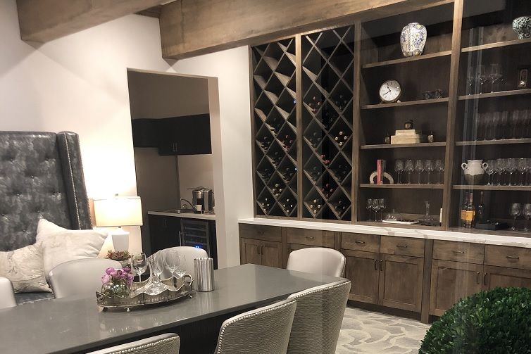 A modern dining room with a wine rack and stylish furnishings.