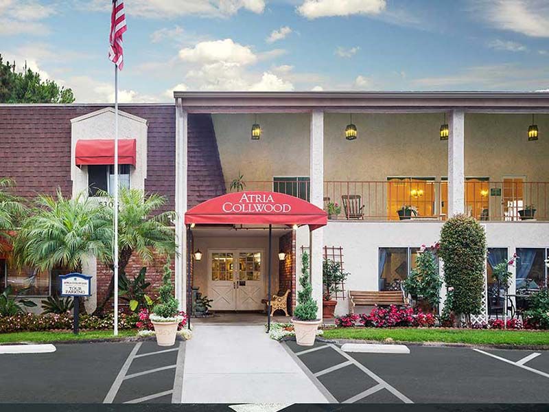 The exterior entrance of a hotel with red awnings and an American flag.