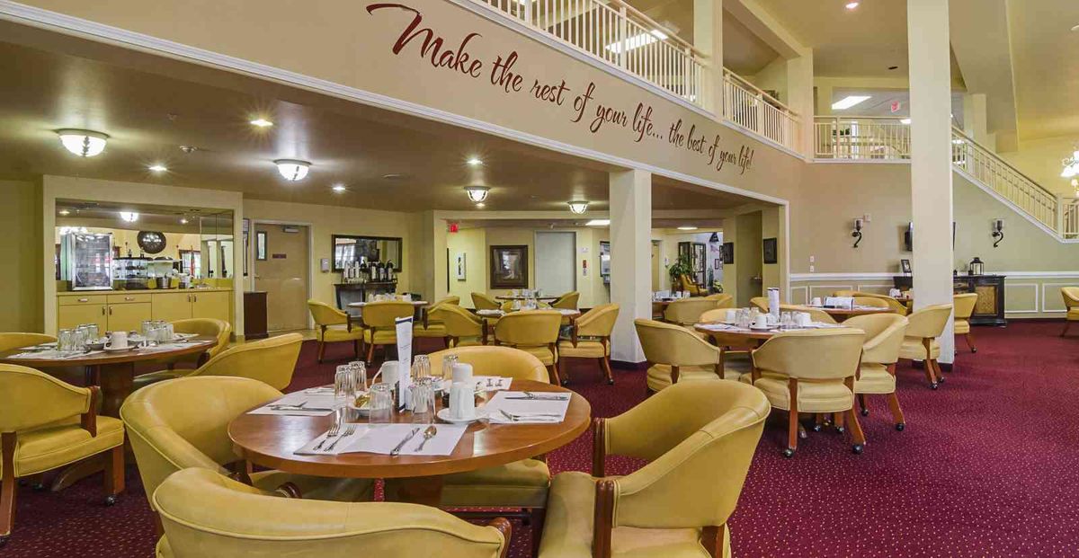 A cozy restaurant dining area with comfortable seating and a motivational quote on the wall.