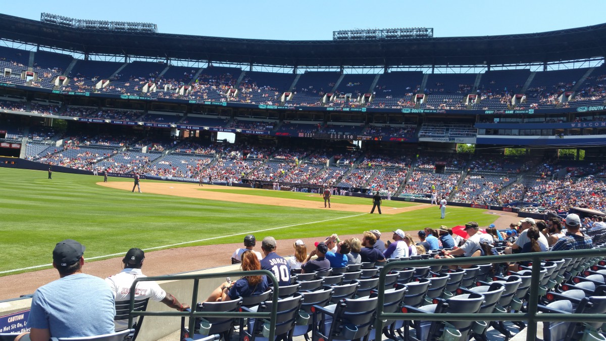 A sunny day at the baseball stadium with fans watching the game.