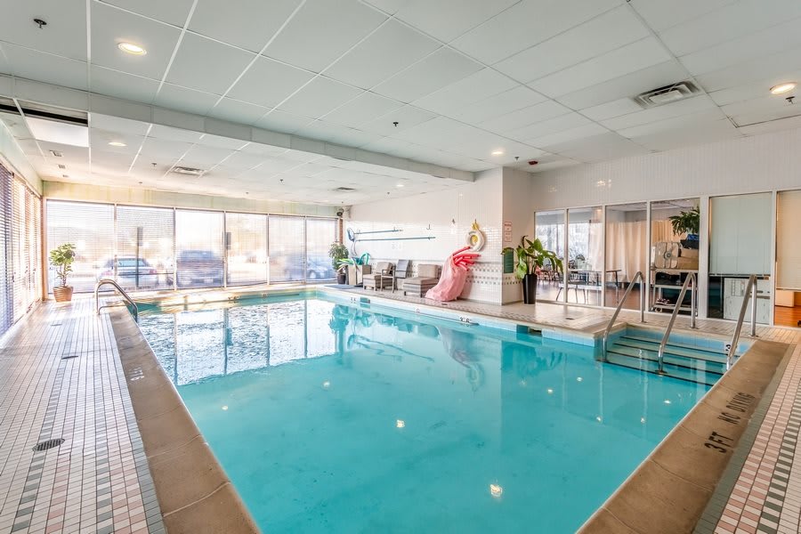 An indoor swimming pool area at a hotel, featuring bright windows and a flamingo decoration.