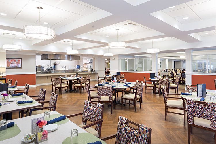 A modern dining area with neatly arranged tables and chairs.