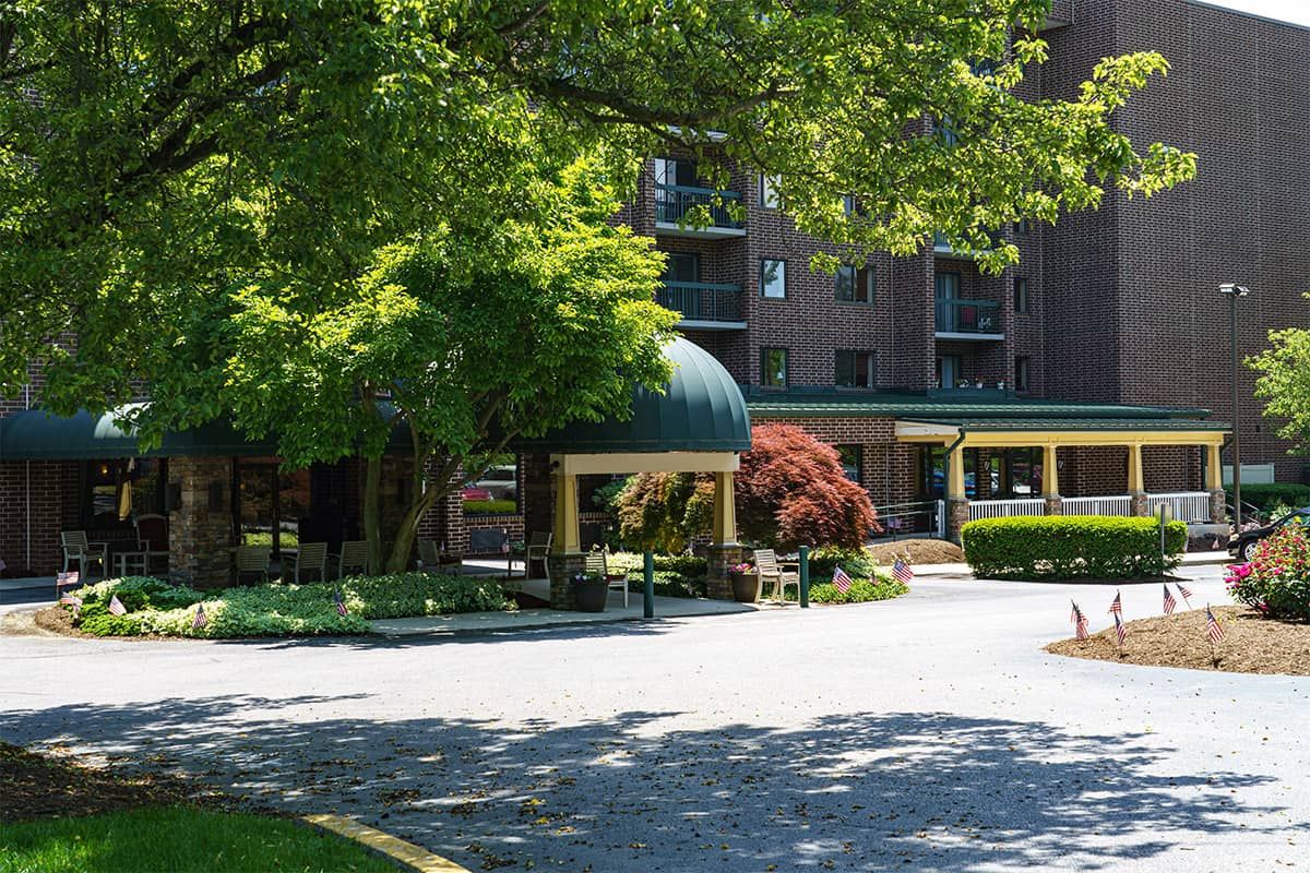 A hotel entrance surrounded by lush greenery and trees.