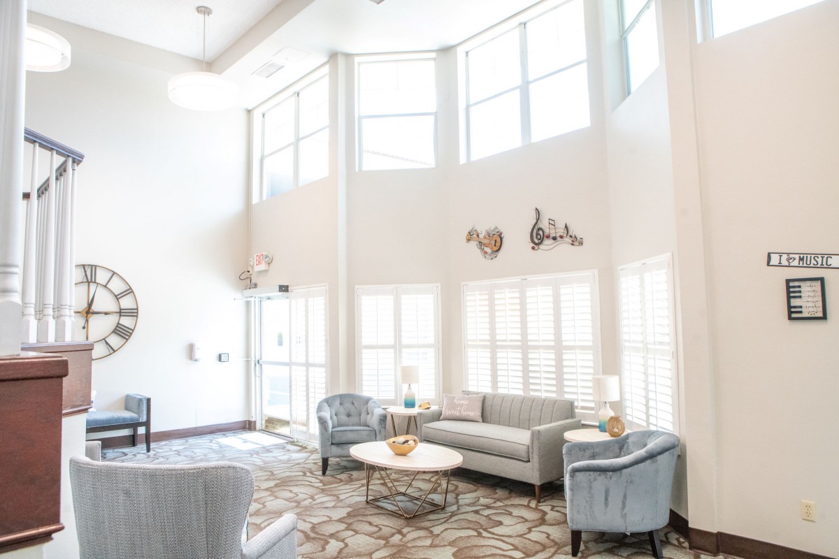 A bright and modern living room interior with large windows and stylish furniture.