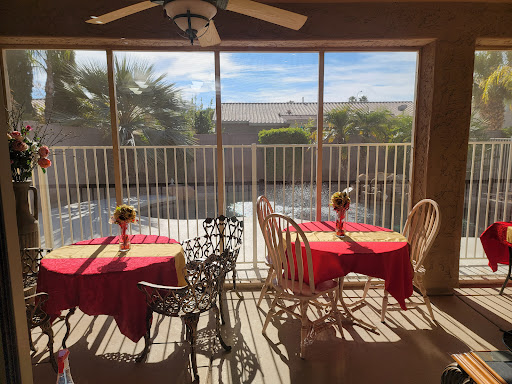 A cozy dining area with red tablecloths, offering a bright view through large windows.