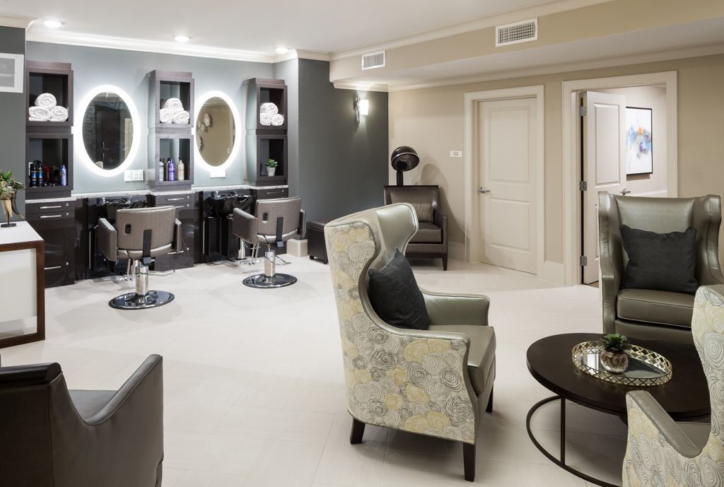 A modern salon interior with comfortable chairs and stylish mirrors.
