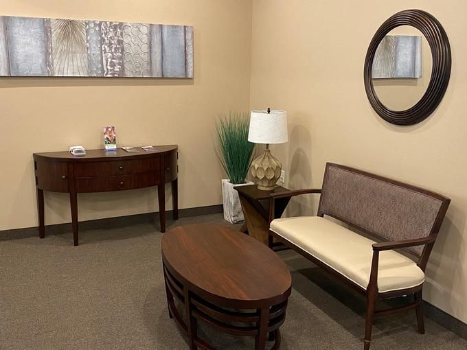A cozy waiting room with a bench, table, and decorative items.