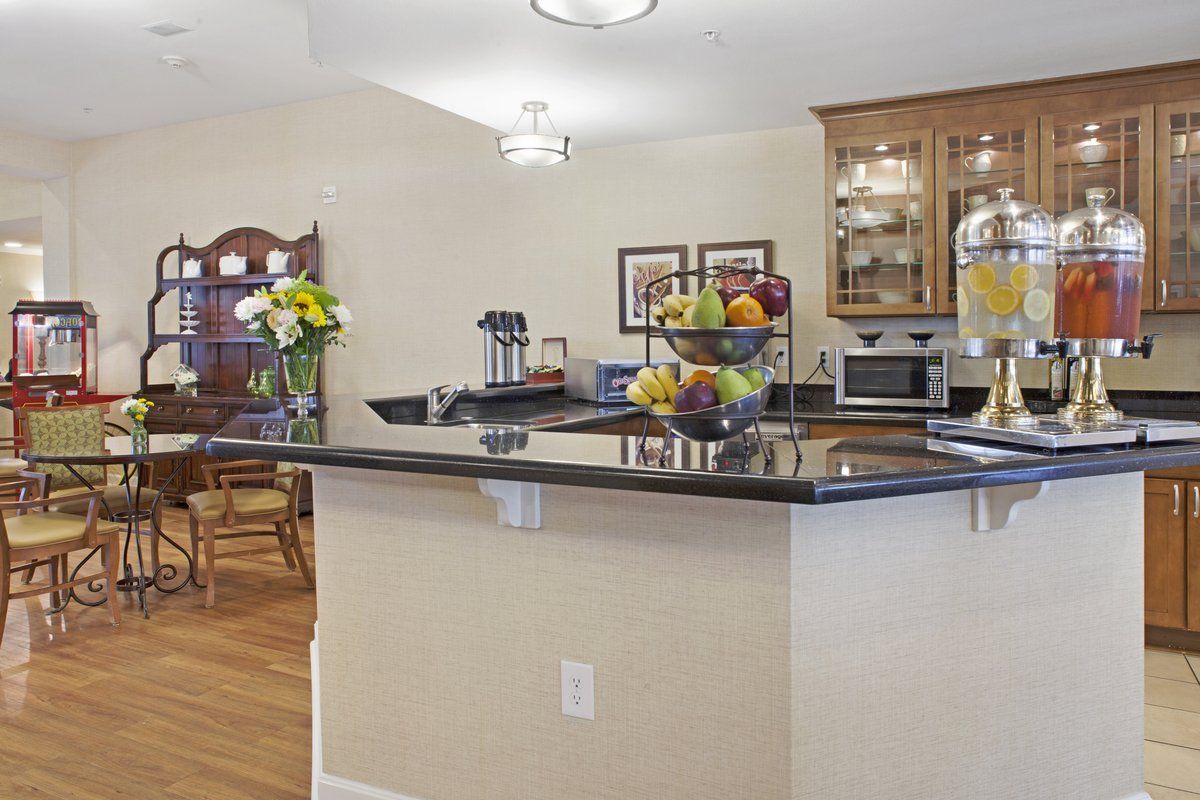 A cozy kitchen with a granite countertop, dining area, and various appliances.