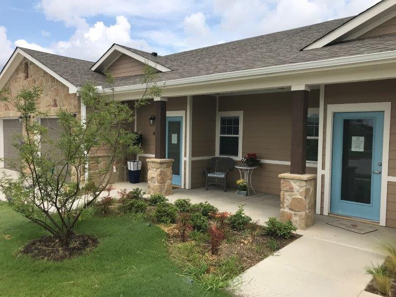 A charming residential house with a small garden and a welcoming porch.