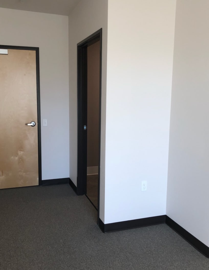 An empty room with two doors and plain walls.