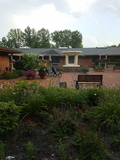 A serene outdoor space featuring a well-maintained garden and seating arrangements, inviting relaxation.