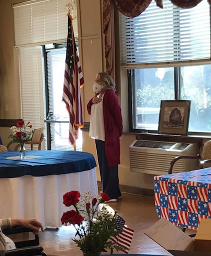 A ceremonial event where a speaker stands by the American flag.