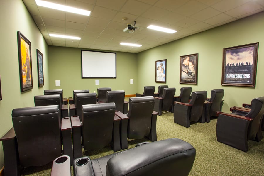A cozy home theater room with comfortable seating and a projector screen.