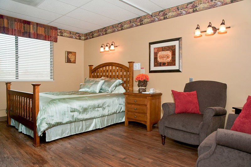 Cozy bedroom with a bed, nightstand, and armchair.