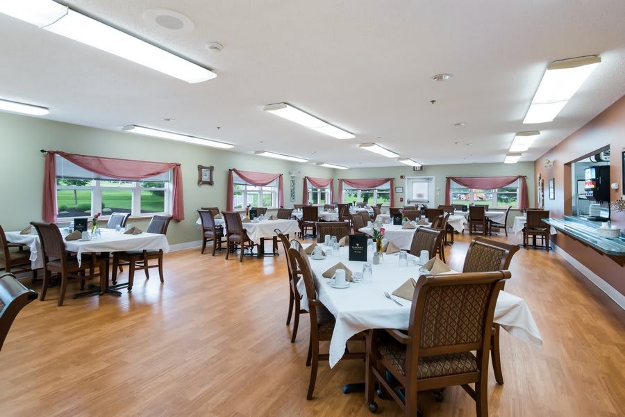 A spacious dining room with neatly arranged tables and chairs.