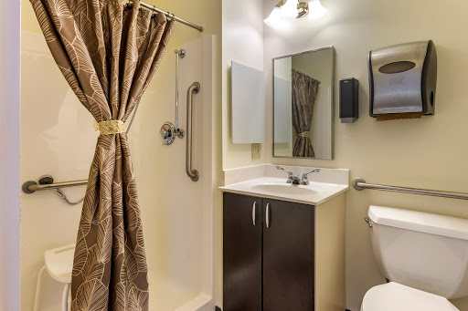 A modern bathroom featuring a shower, sink, and elegant curtains.
