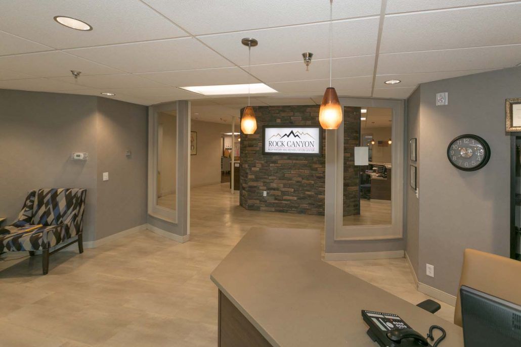 A modern office lobby with a reception desk and elegant lighting.