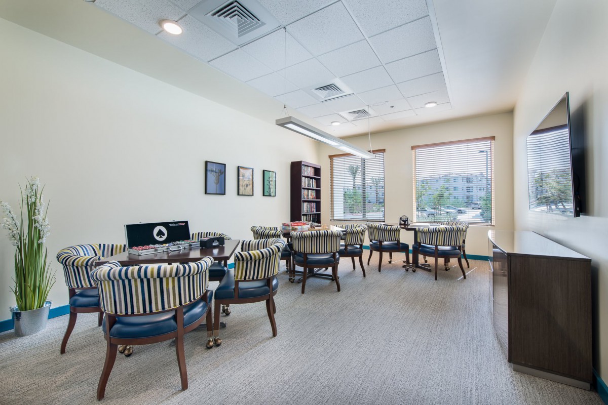 A well-lit meeting room with tables and chairs arranged in an office setting.