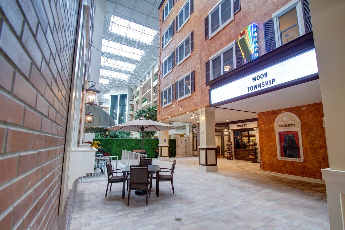 A modern indoor atrium with seating and natural light from skylights.