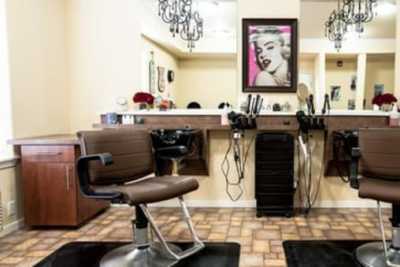 A stylish hair salon interior with a barber chair, mirrors, and chic decor.