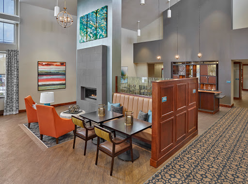 A modern and inviting lobby space featuring comfortable seating, a fireplace, and artistic decor.