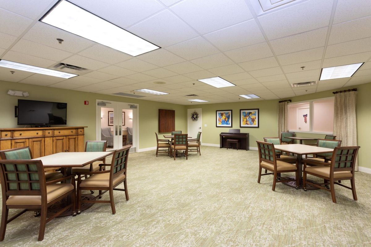 A spacious interior room with tables and chairs, decorated in neutral tones.