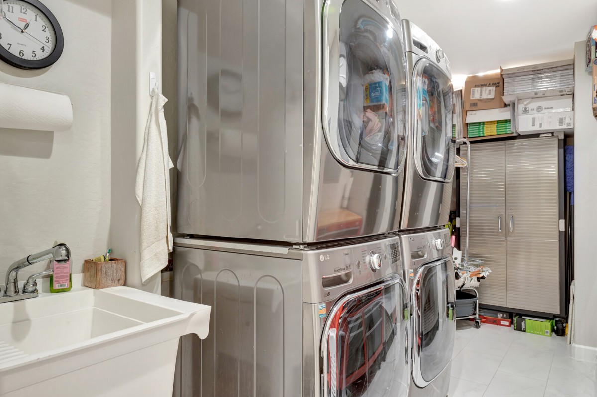Stacked industrial washing machines in a laundry room.