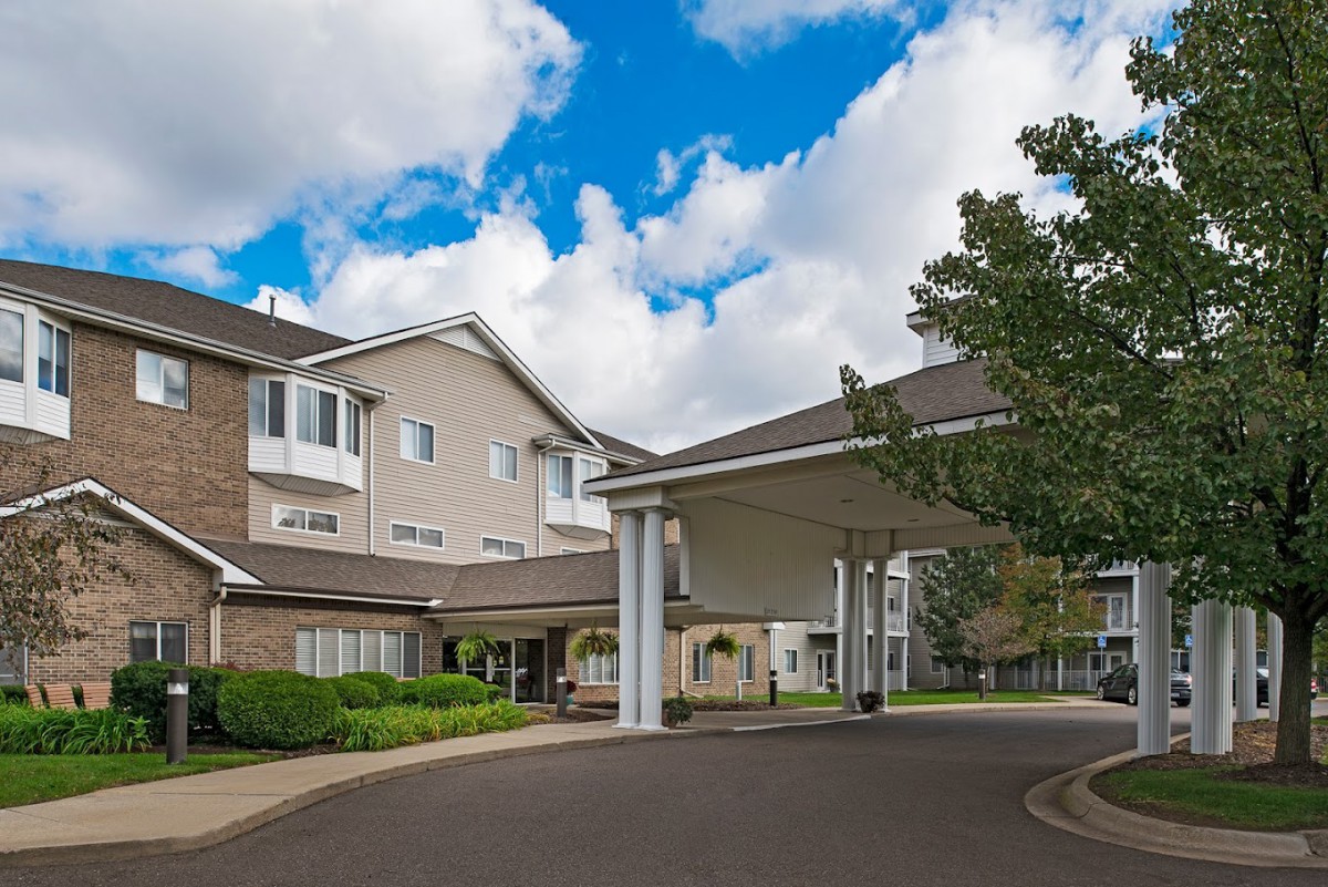 A welcoming entrance to a modern building under a partly cloudy sky.