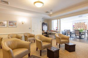 A cozy waiting room with beige chairs and a warm ambiance.