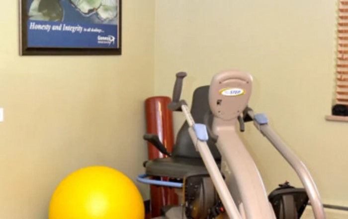 A corner of a gym with exercise equipment and therapy tools.