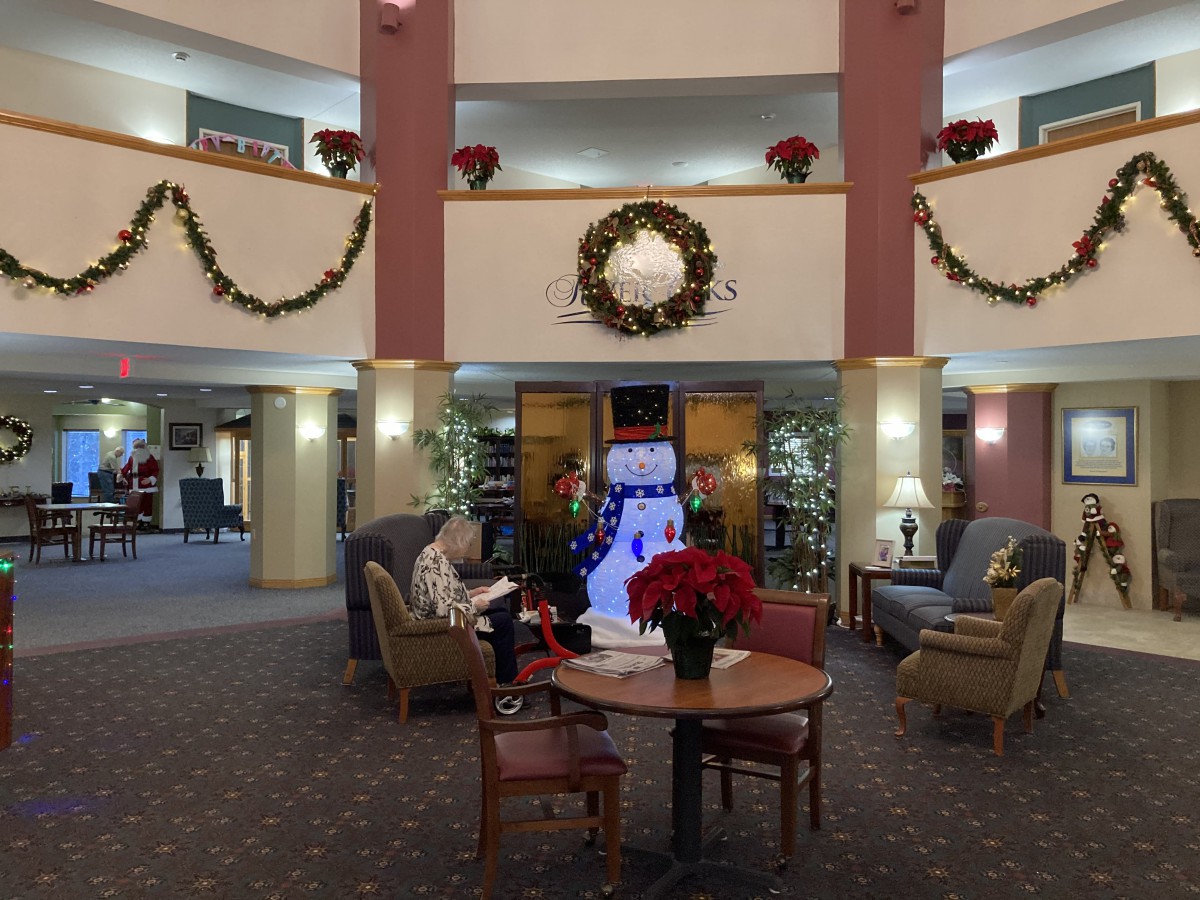 A festive lobby decorated for the holidays with a large wreath and poinsettias.