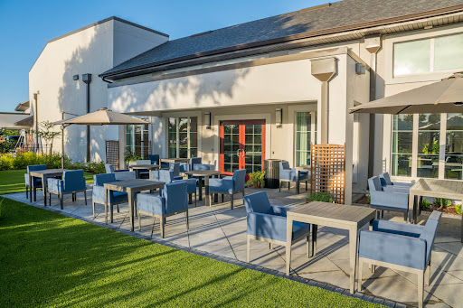 A modern outdoor patio with comfortable seating, perfect for dining in the sunlight.