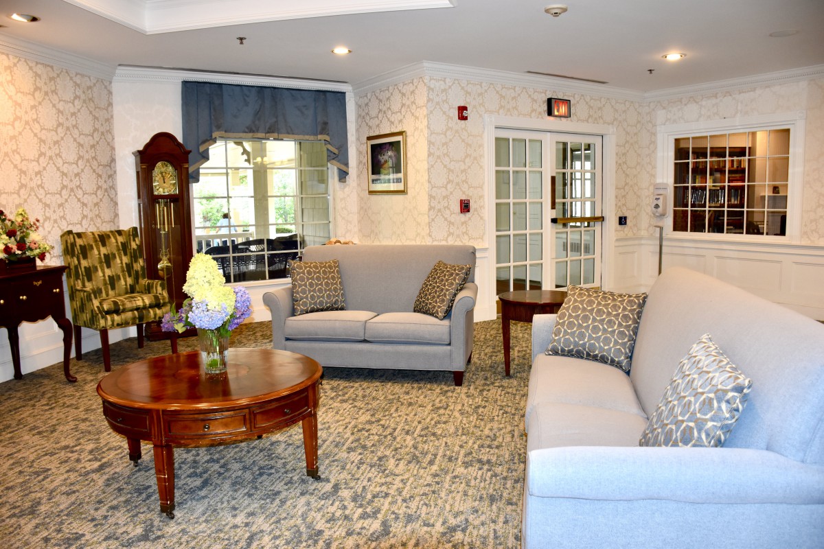 A cozy living room with sofas, a wooden coffee table, and a grandfather clock.