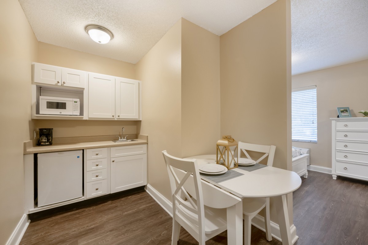 A compact kitchen and dining area with a small table and two chairs.