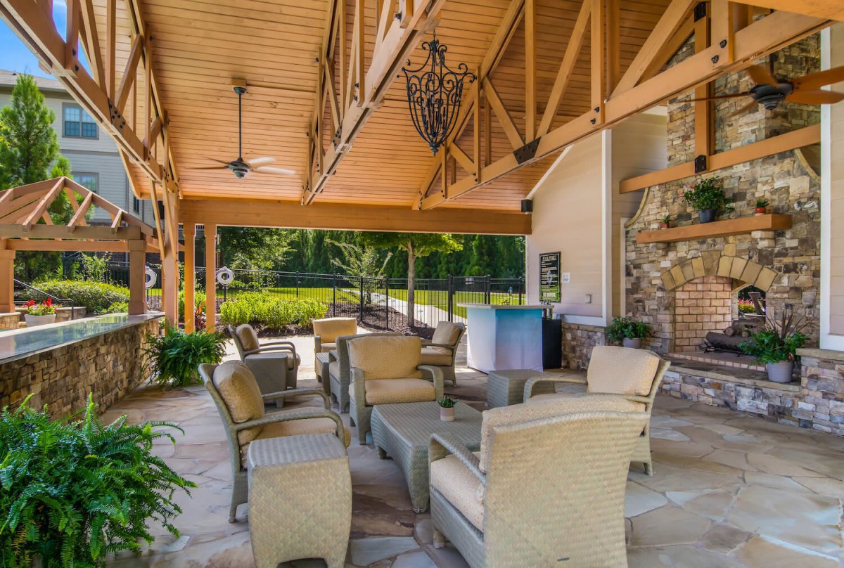 A cozy outdoor patio with comfortable seating and a view of lush greenery.
