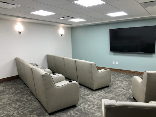 A modern lounge area with comfortable seating and a large television.