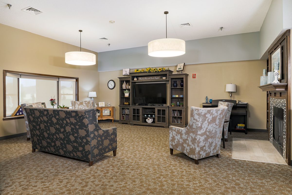 A cozy living room with comfortable seating and a large TV entertainment center.