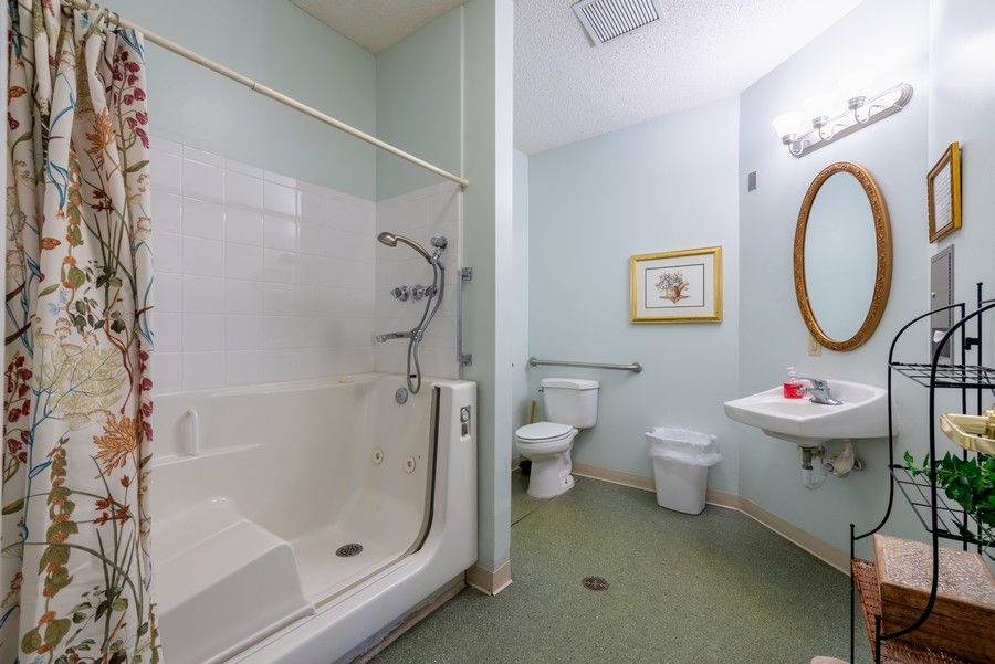 A clean and accessible bathroom with a shower, toilet, and sink.