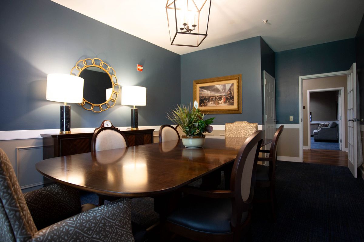 Elegant dining room with a large wooden table, upholstered chairs, and tasteful decor.