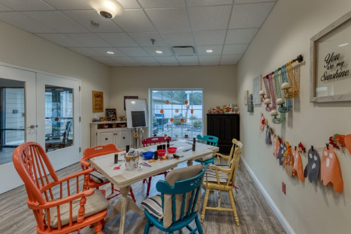 A cozy art studio with colorful chairs and a table set up for crafting activities.