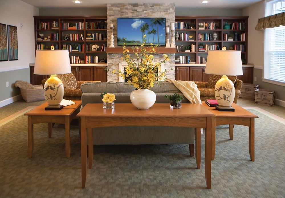 A cozy living room with bookshelves, a sofa, coffee table, and elegant decor.