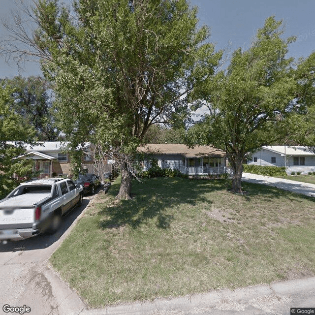 A suburban house with a grassy front yard and a pickup truck parked in the driveway.